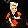 baby, child, halloween, dress, headband, bow, orange, black, costume, sitting, portrait, cute, smiling, face, blue_eyes, infant, background, chain, holiday, festive