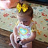 Hartley May is registered to the contest to win money with this photo: alphabet, animals, baby, baby_clothing, child, colorful, couch, focused, gadget, hair, indoor, living_room, play_mat, plush_chair, portrait, sitting, toddler, toy, wood_floor, yellow_bow