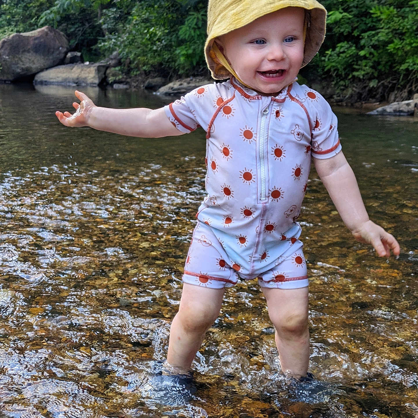 Bellamy is registered to the contest to win money with this photo: baby, clothing, face, hat, head, land, nature, outdoors, person, photography, plant, portrait, rainforest, rock, shorts, soil, summer, tree, vegetation, water