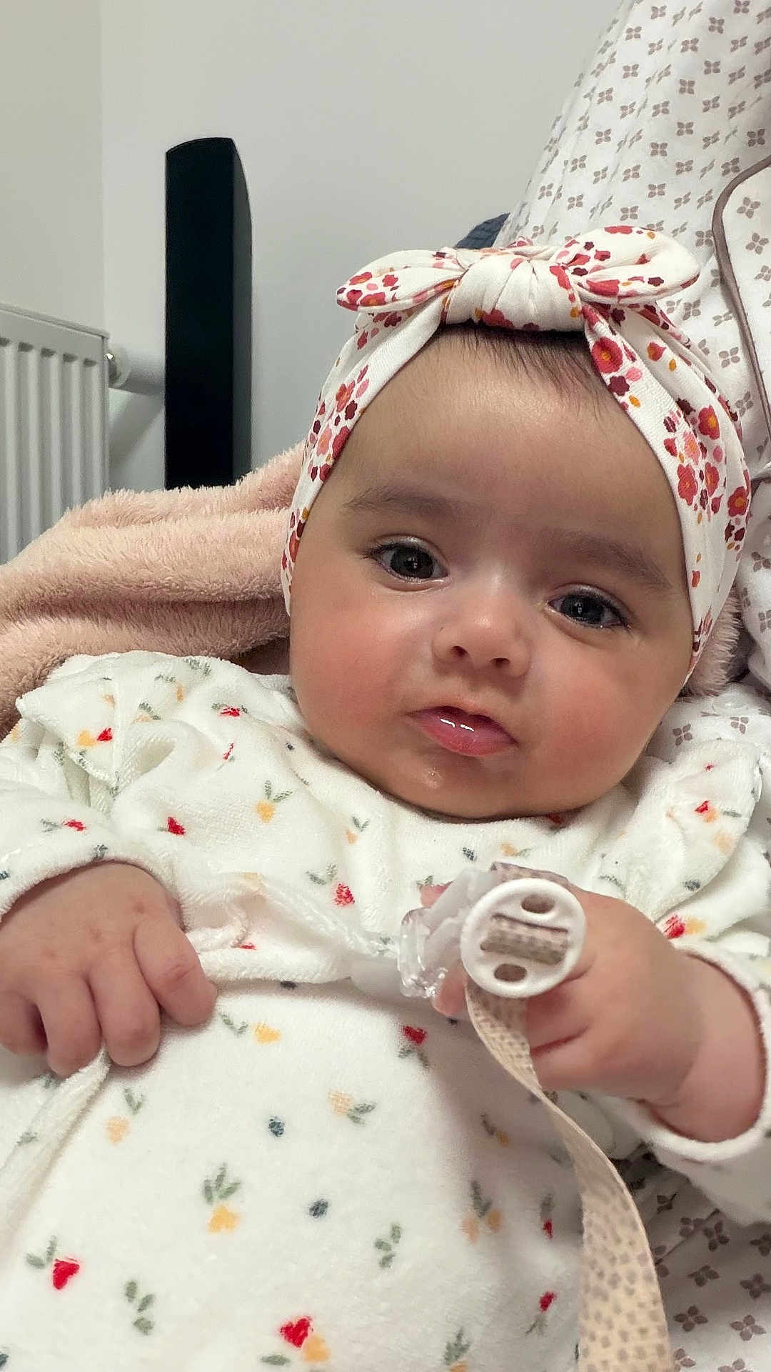 Amélia participe au concours pour gagner de l'argent avec cette photo : baby, infant, headband, floral, pacifier, blanket, clothing, cute, child, face, hand, indoors, portrait, expression, soft, warm, young, person, newborn, comfort