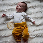Achille a rejoint le concours — aidez-le/la à gagner de superbes lots ! 2_months, baby, bare_feet, child, cozy, cute, fluffy_blanket, happy, indoors, infant, lying_down, milestone, newborn, portrait, small_hands, smiling, soft_texture, white_onesie, wooden_plaque, yellow_pants