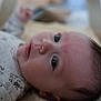Achille participe au concours pour gagner de l'argent avec cette photo : baby, blurred_background, close_up, clothing, curious, expression, eyes, face, head, indoors, infant, lying_down, newborn, peaceful, person, portrait, skin, sleepwear, soft_surface, young_child