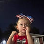 child, girl, bow, american_flag, red_shirt, night, outdoor, shoulders, suburban, house, door, light, person, portrait, thinking, cute, blonde, face, hand, expression