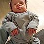 baby, infant, newborn, sleeping, sweater, hands, fingers, legs, shoe, socks, person, portrait, indoor, wood_floor, knitwear, cozy, soft_lighting, closed_eyes, resting, hair_spikes