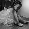 Gabriella participe au concours pour gagner de l'argent avec cette photo : child, girl, dress, shoe, sock, floor, indoor, black_and_white, portrait, concentration, sitting, wooden_floor, furniture, hair, cute, toddler, bracelet, tattoo, wall, light