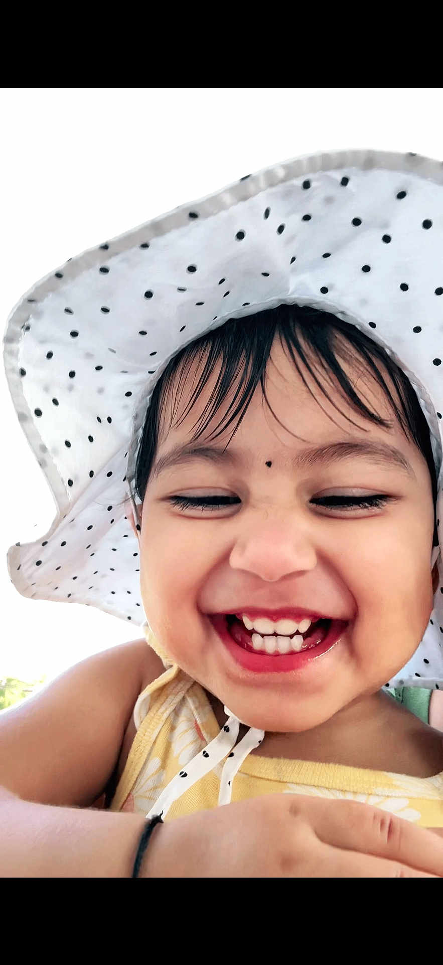 Shreeja is registered to the contest to win money with this photo: toddler, child, smiling, laughing, hat, polka_dot, white, yellow, happy, outdoor, face, closeup, teeth, skin, person, summer, sunhat, cute, joyful, fun