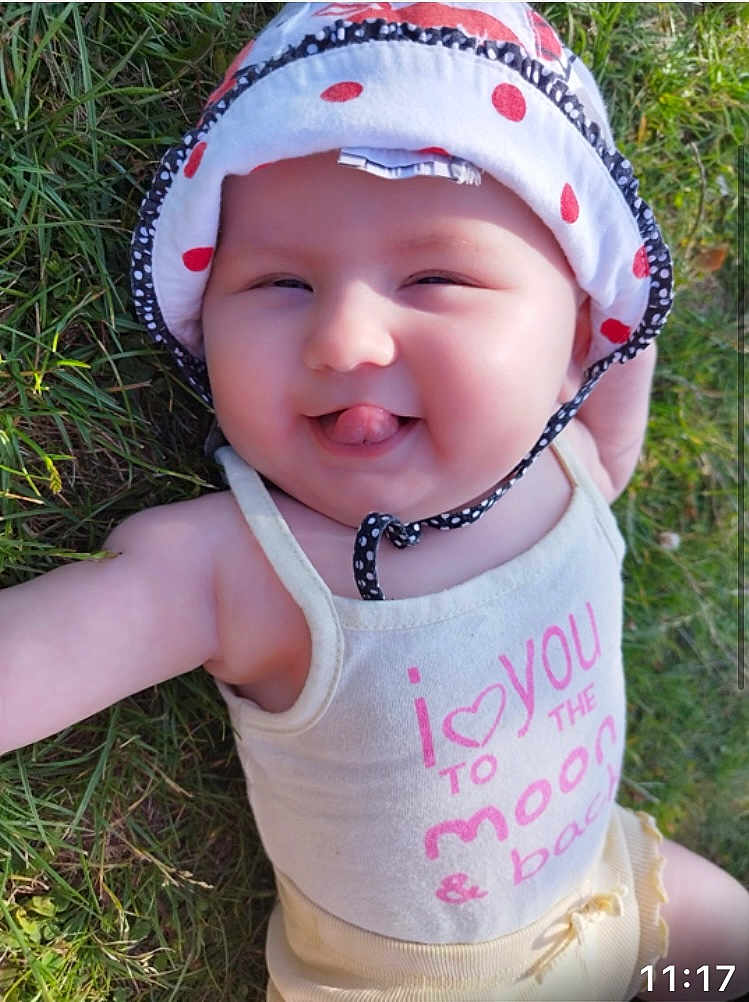 Iris a rejoint le concours — aidez-le/la à gagner de superbes lots ! baby, grass, hat, tank_top, smiling, tongue_out, outdoor, child, cute, sunlight, polka_dot, infant, playful, happy, apparel, headwear, nature, person, summer, closeup