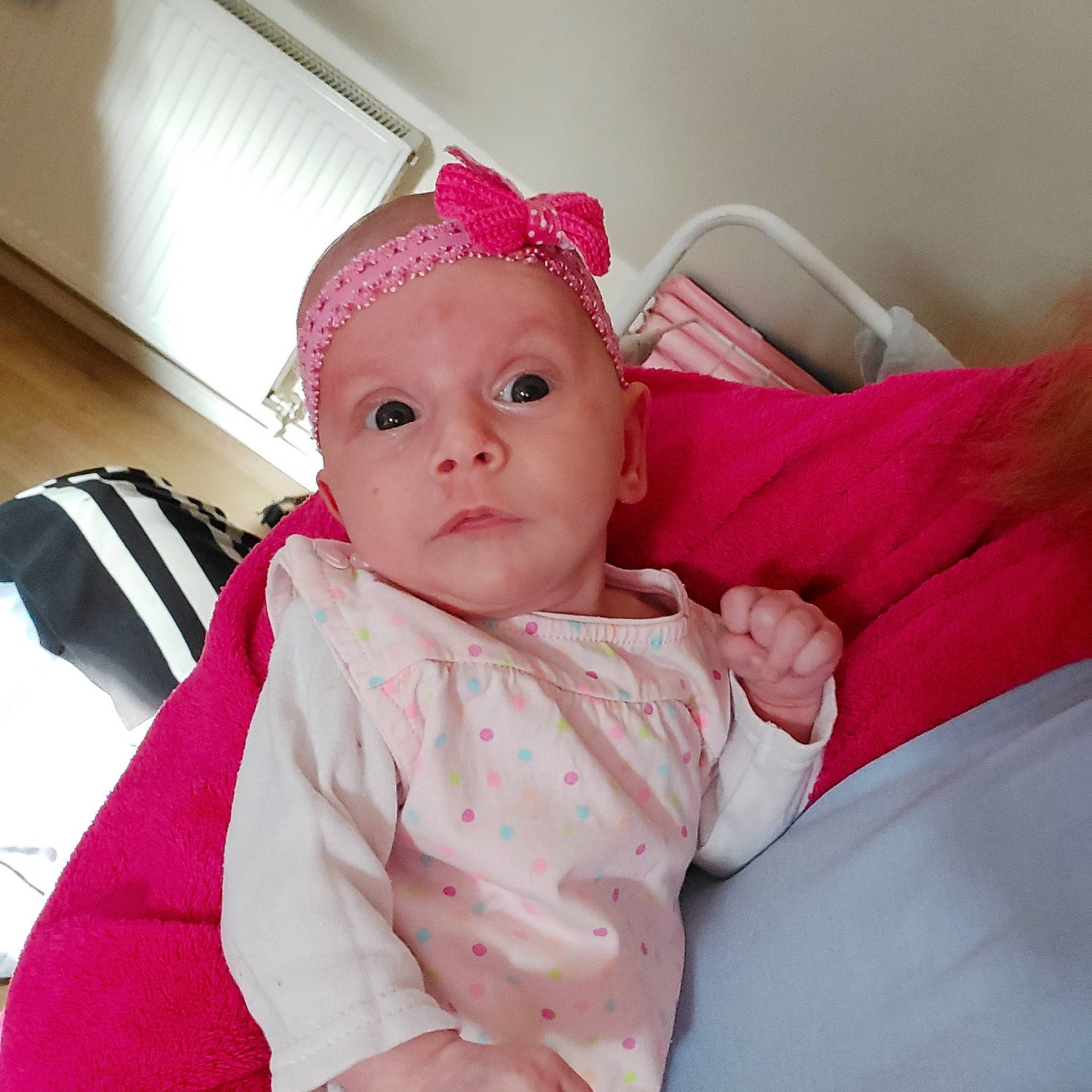 Délina participe au concours pour gagner de l'argent avec cette photo : baby, baby_products, baby_toddler_clothing, cap, cheek, child, comfort, face, facial_expression, fashion_accessory, fun, happy, linens, lip, magenta, person, pink, sitting, skin, sleeve