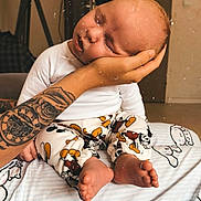 Ezio a rejoint le concours — aidez-le/la à gagner de superbes lots ! baby, infant, sleeping, hand, tattoo, pants, cartoon_print, blanket, indoor, lamp, foot, person, head, cozy, bedroom, rest, comfort, soft, cute, peaceful