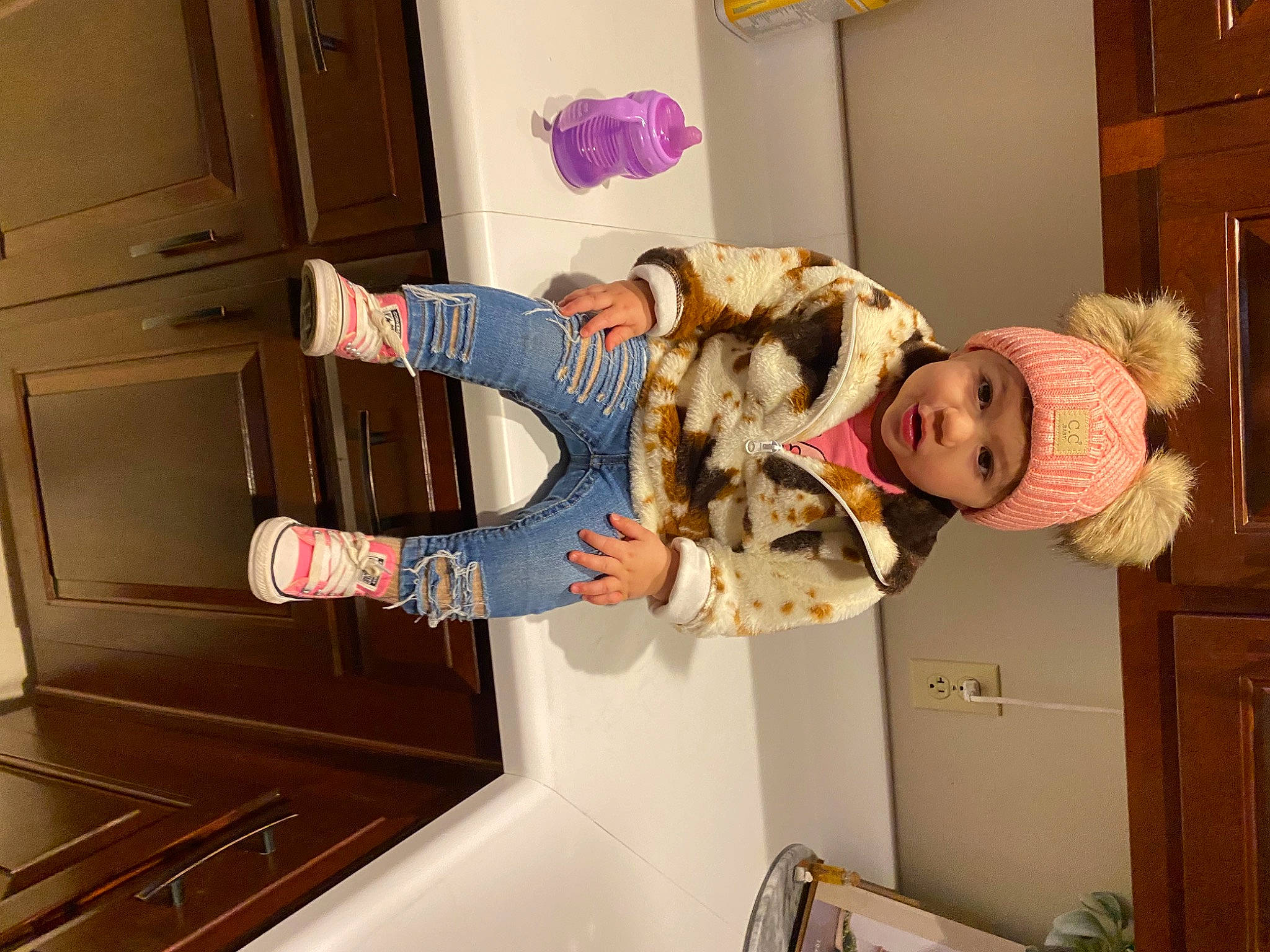 Evelyn is registered to the contest to win money with this photo: cabinetry, child, cupboard, drawer, flooring, fun, fur, happy, headwear, kitchen, person, plant, room, shelf, shelving, toddler, tree, wood