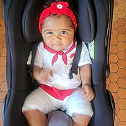 Enëa participe au concours pour gagner de l'argent avec cette photo : baby, black, car_seat, child, cute, flower, hands, headband, indoor, infant, legs, looking, person, red, seat, secure, smile, straps, tiled_floor, white_clothing