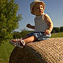 Louis participe au concours pour gagner de l'argent avec cette photo : blue_sky, casual_clothing, child, daylight, expression, field, grass, greenery, hat, hay_bale, nature, outdoor, portrait, rural, sitting, sneakers, summer, sunny, toddler, young_child