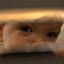blurred, child, close_up, curious, expression, eyebrow, eyes, face, focus, head, indoor, intimate, mystery, observation, person, portrait, reflection, skin, soft_light, young