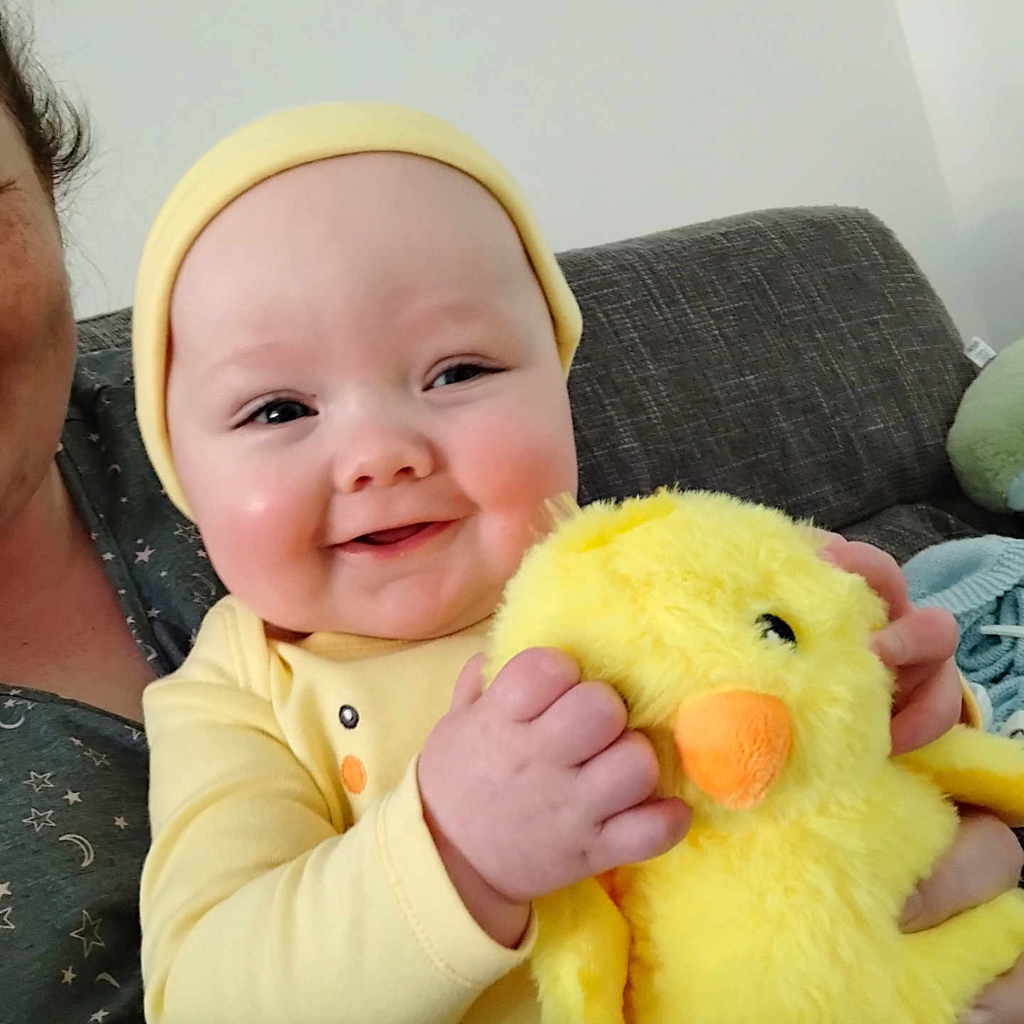 Oliver is registered to the contest to win money with this photo: baby, child, comfort, couch, cozy, cute, furniture, hand, happy, headwear, holding, indoor, infant, person, plush_toy, portrait, smiling, soft_toy, stuffed_animal, yellow_clothing