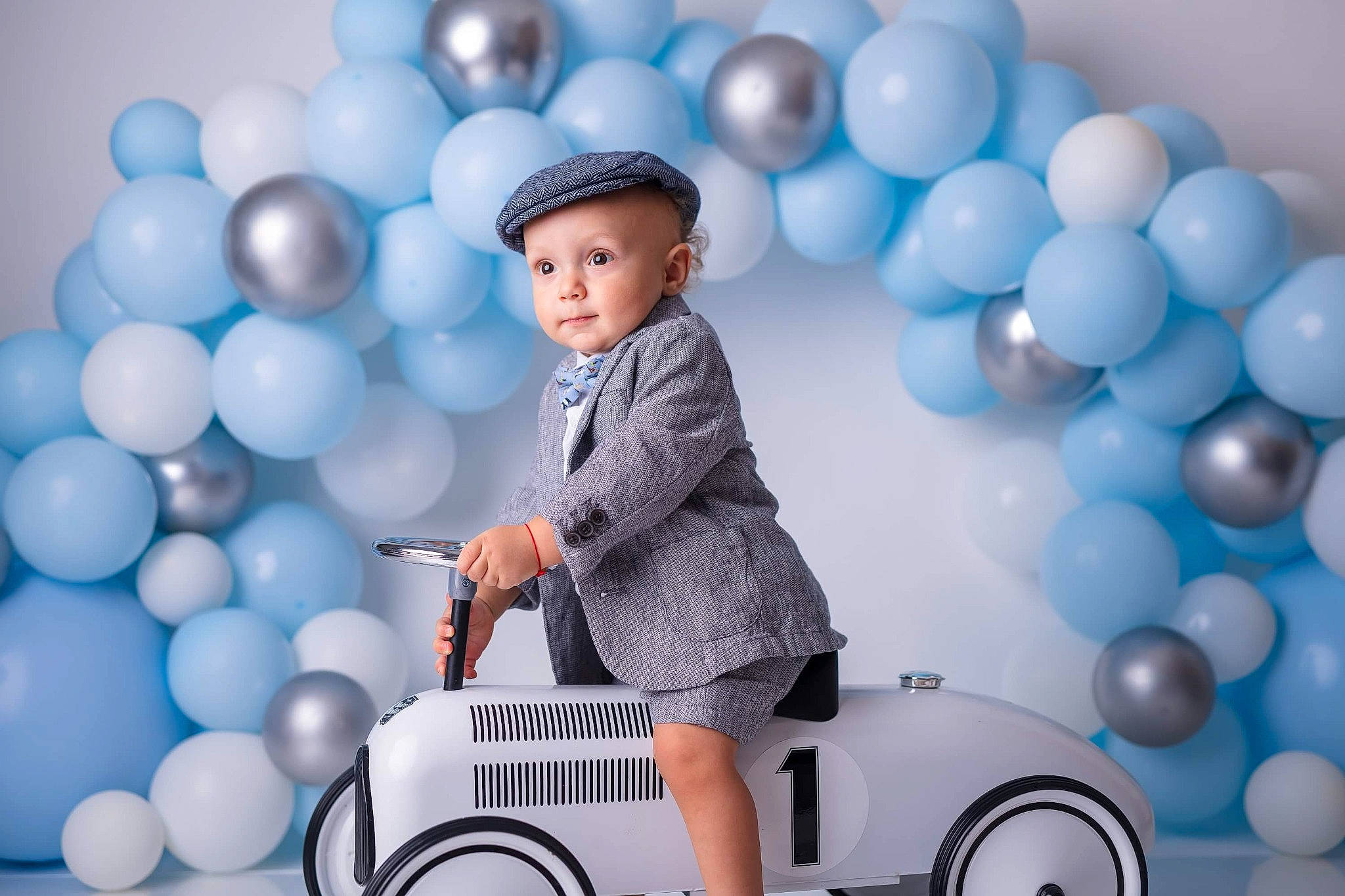 Matei is registered to the contest to win money with this photo: balloon, blue, headwear, human, party, party_supply, person, plastic, riding_toy, sphere, toy