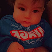 Lucian is registered to the contest to win money with this photo: baby, infant, child, face, cheeks, eyes, hair, hoodie, clothing, diaper, hand, fist, portrait, closeup, indoors, sitting, cute, chubby, expression_serious, soft_lighting