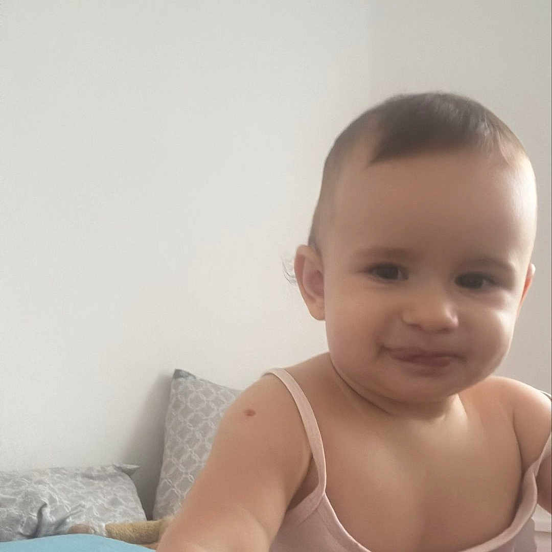Selvi a rejoint le concours — aidez-le/la à gagner de superbes lots ! baby, bed, cartoon_character, child, clothing, cute, face, indoor, person, pillow, playful, red_bedspread, room, short_hair, skin, smiling, tank_top, toddler, tom_and_jerry, white_wall