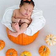 Evelyn joined the competition — help win amazing prizes! baby, infant, sleeping, pumpkin, halloween, hat, orange_bow, blanket, white, cute, festive, decorative_pumpkins, holiday, costume, headwear, child, autumn, seasonal, portrait, soft