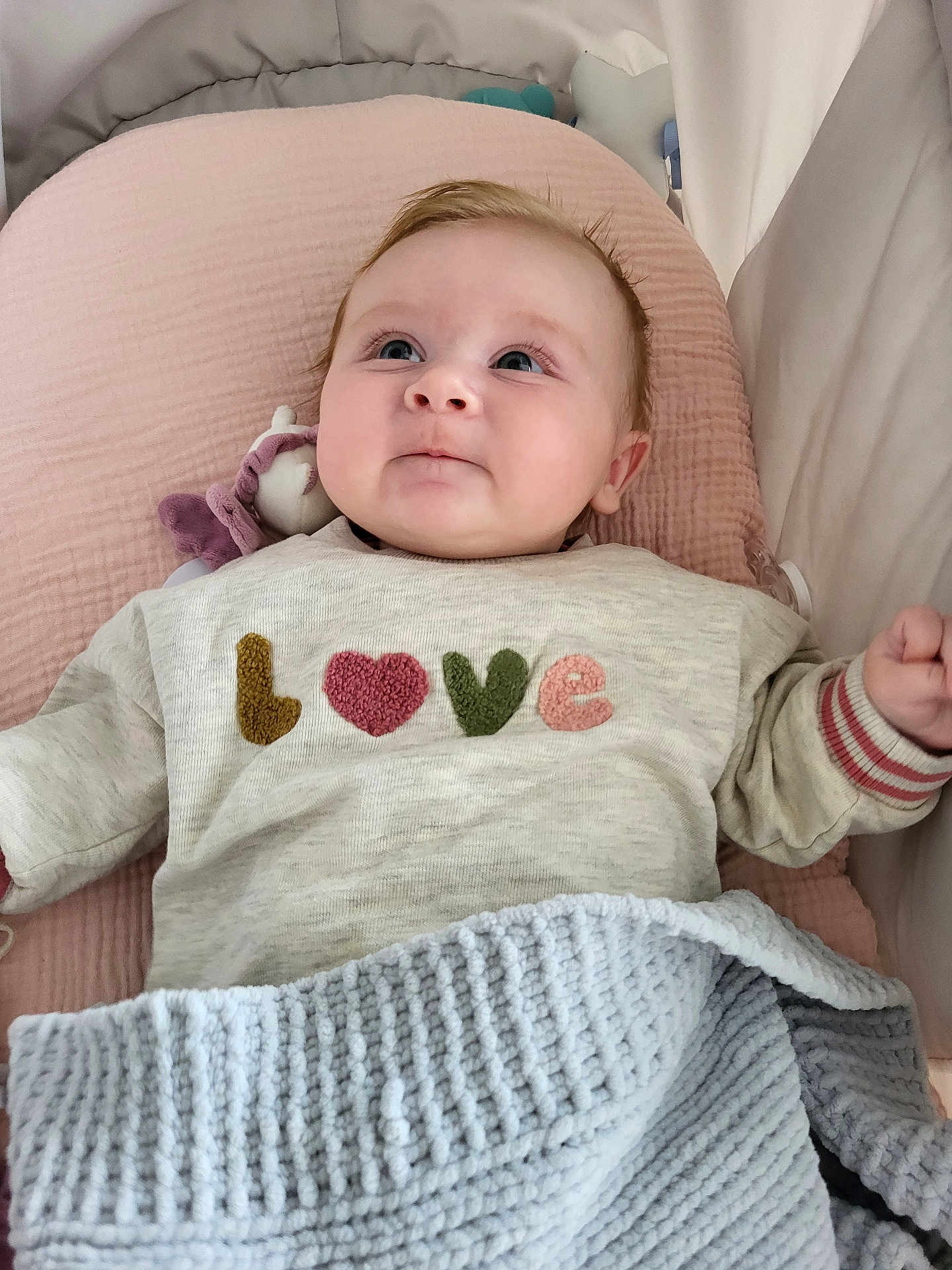 Anna participe au concours pour gagner de l'argent avec cette photo : baby, infant, child, face, sweater, love_text, blanket, pink_cushion, knitted, blue_blanket, lying_down, indoors, cute, young_child, portrait, cozy, soft_texture, sleeping_area, hand, expression