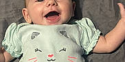 Cierra joined the competition — help win amazing prizes! arm, baby, blanket, cat_face, cheerful, child, clothing, cute, happy, indoor, infant, lying_down, pale_blue, person, shirt, small_hands, smiling, soft_texture, toddler, young_child