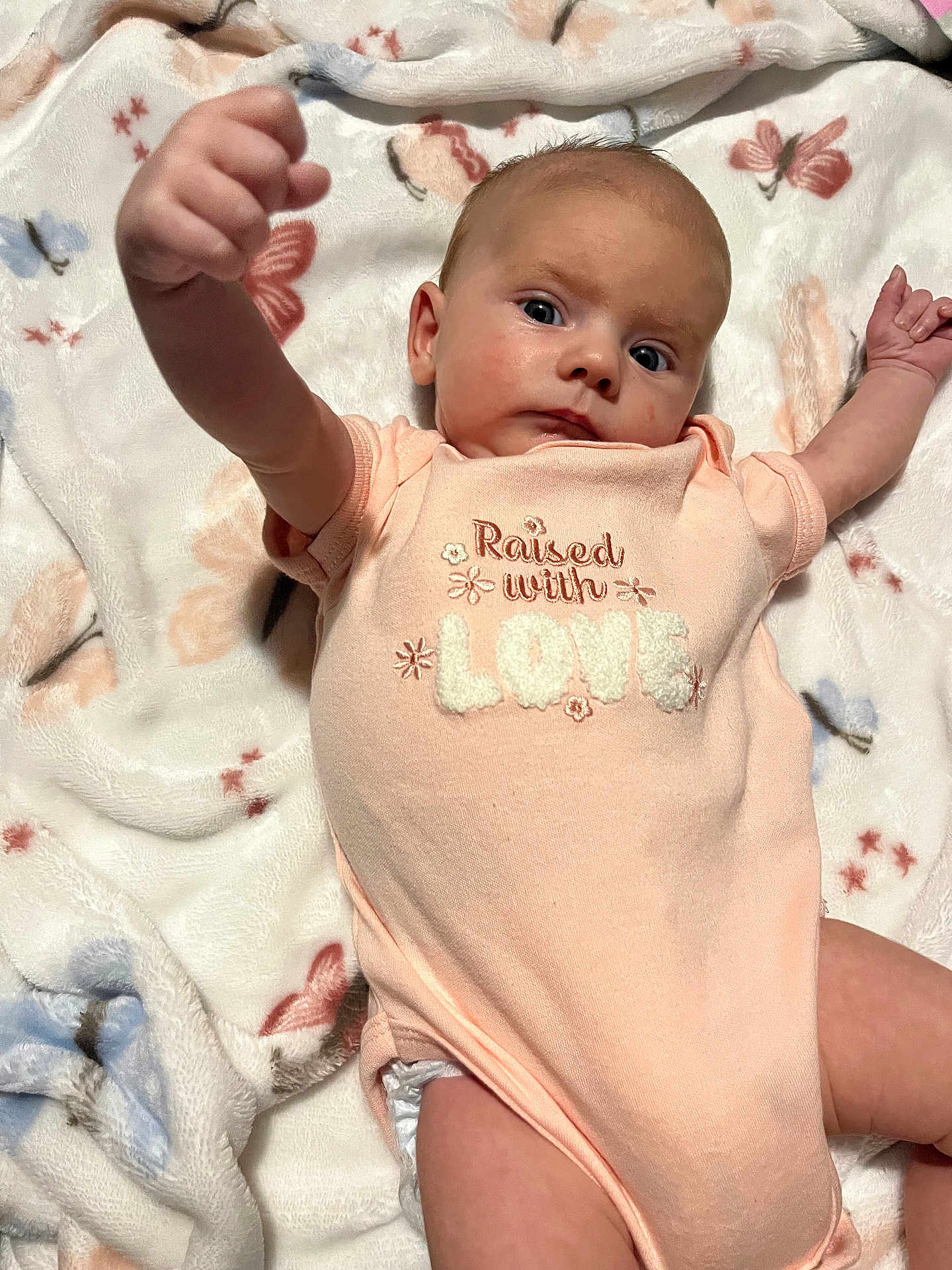 Cierra joined the competition — help win amazing prizes! baby, infant, onesie, blanket, butterfly, laying_down, raised_arm, cute, child, face, expression, soft_texture, fabric, pink, white, pattern, person, newborn, portrait, indoor