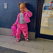 Ahyokaa is registered to the contest to win money with this photo: toddler, child, pink_jacket, pink_pants, heart_pattern, backpack, smile, indoor, floor_tiles, door, glass, window, wall, electric_outlet, shoe, person, hair_puffs, playful, gesture, parking_lot