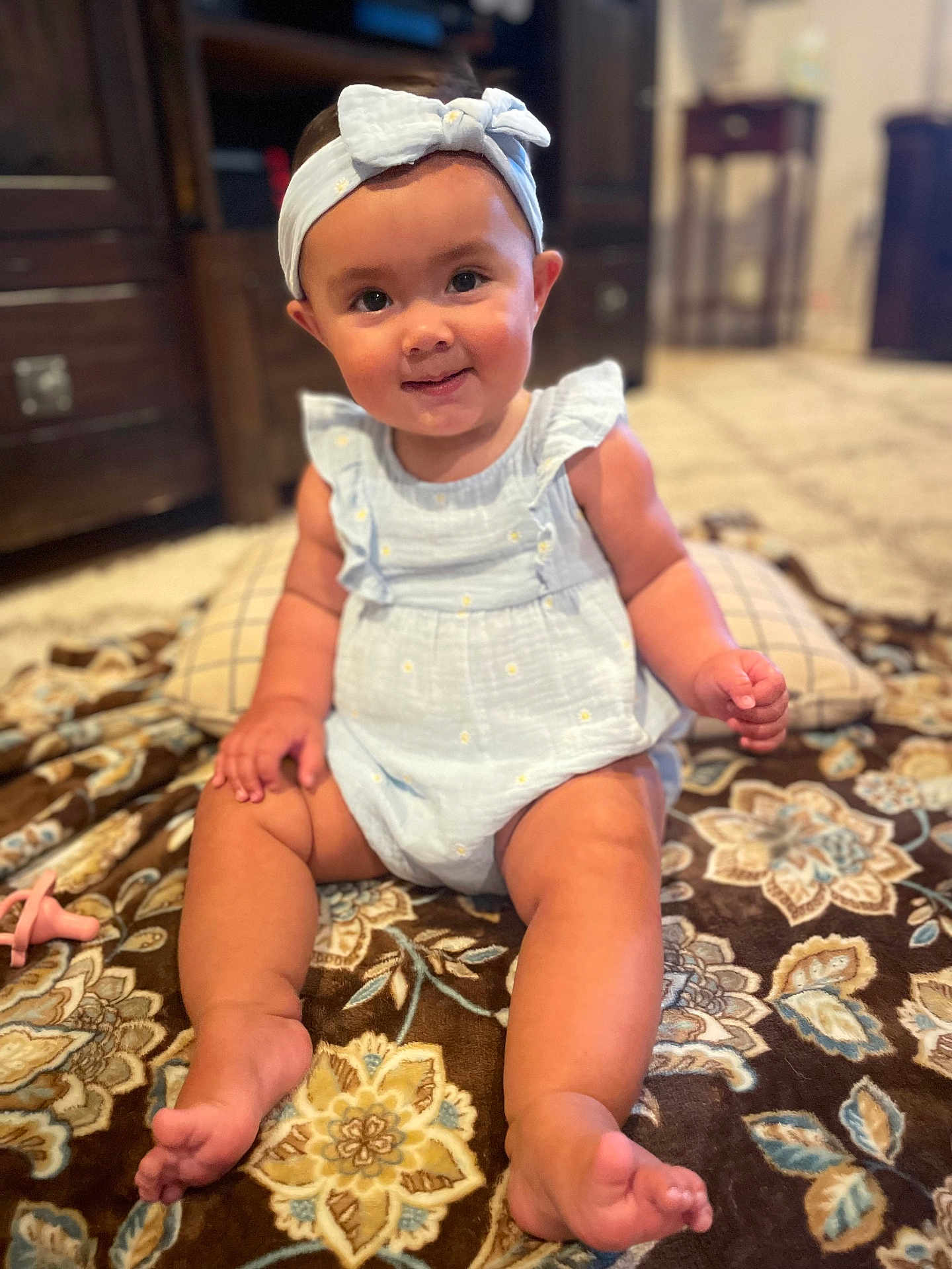 Athena joined the competition — help win amazing prizes! baby, child, infant, smiling, blue_clothing, headband, sitting, blanket, indoor, carpet, pacifier, furniture, face, cute, happy, person, portrait, baby_girl, skin, home