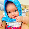 baby, infant, child, portrait, sitting, blue_hood, hooded_clothing, colorful_clothing, cartoon_shorts, couch, indoor, close_up, face, eyes, hands, baby_fashion, bunny_sticker, smiling, adorable, photography