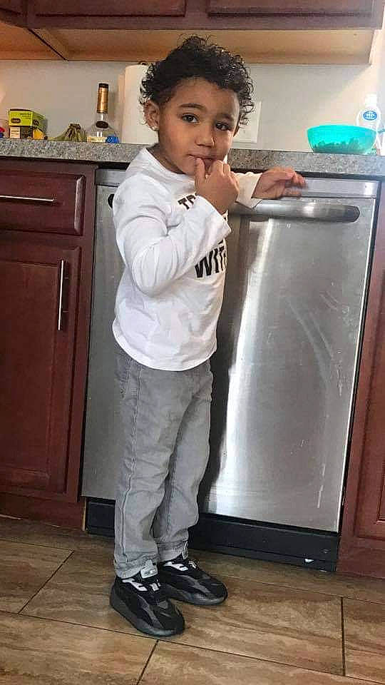 Avion is registered to the contest to win money with this photo: cabinetry, cleanliness, cooking, countertop, drawer, flooring, gas, home_appliance, homemaker, kitchen, kitchen_appliance, major_appliance, person, photograph, refrigerator, room, standing, toddler, waste_container, waste_containment