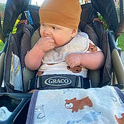 Lincoln joined the competition — help win amazing prizes! baby, child, stroller, hat, brown_hat, bear_ears, bib, hand, face, clothing, blanket, outdoor, sunlight, curious, cute, infant, seatbelt, graco, toddler, playful