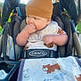 baby, child, stroller, hat, brown_hat, bear_ears, bib, hand, face, clothing, blanket, outdoor, sunlight, curious, cute, infant, seatbelt, graco, toddler, playful