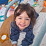 child, toddler, smiling, playmat, toy, indoor, happy, face, clothing, hands, legs, colorful, patterned, soft, cute, baby, play, cushion, person, portrait