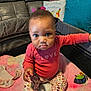 Ruby joined the competition — help win amazing prizes! toddler, child, baby, pink_shirt, floral_pants, sock, blanket, playpen, couch, pillow, indoor, person, face, curious, sitting, soft_toy, home, expression, furniture, cozy