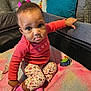 Ruby joined the competition — help win amazing prizes! toddler, child, indoor, playpen, pink_bow, pink_socks, coral_shirt, floral_pants, plush_toy, blanket, couch, pillows, curious, sitting, pointing, face, eyes, person, cozy, home
