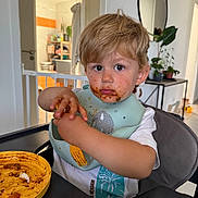 Tom a rejoint le concours — aidez-le/la à gagner de superbes lots ! bib, blonde_hair, child, door, expression, face, food, hands, high_chair, home, indoor, meal_time, messy, mirror, plant, plate, spaghetti, table, toddler, white_shirt