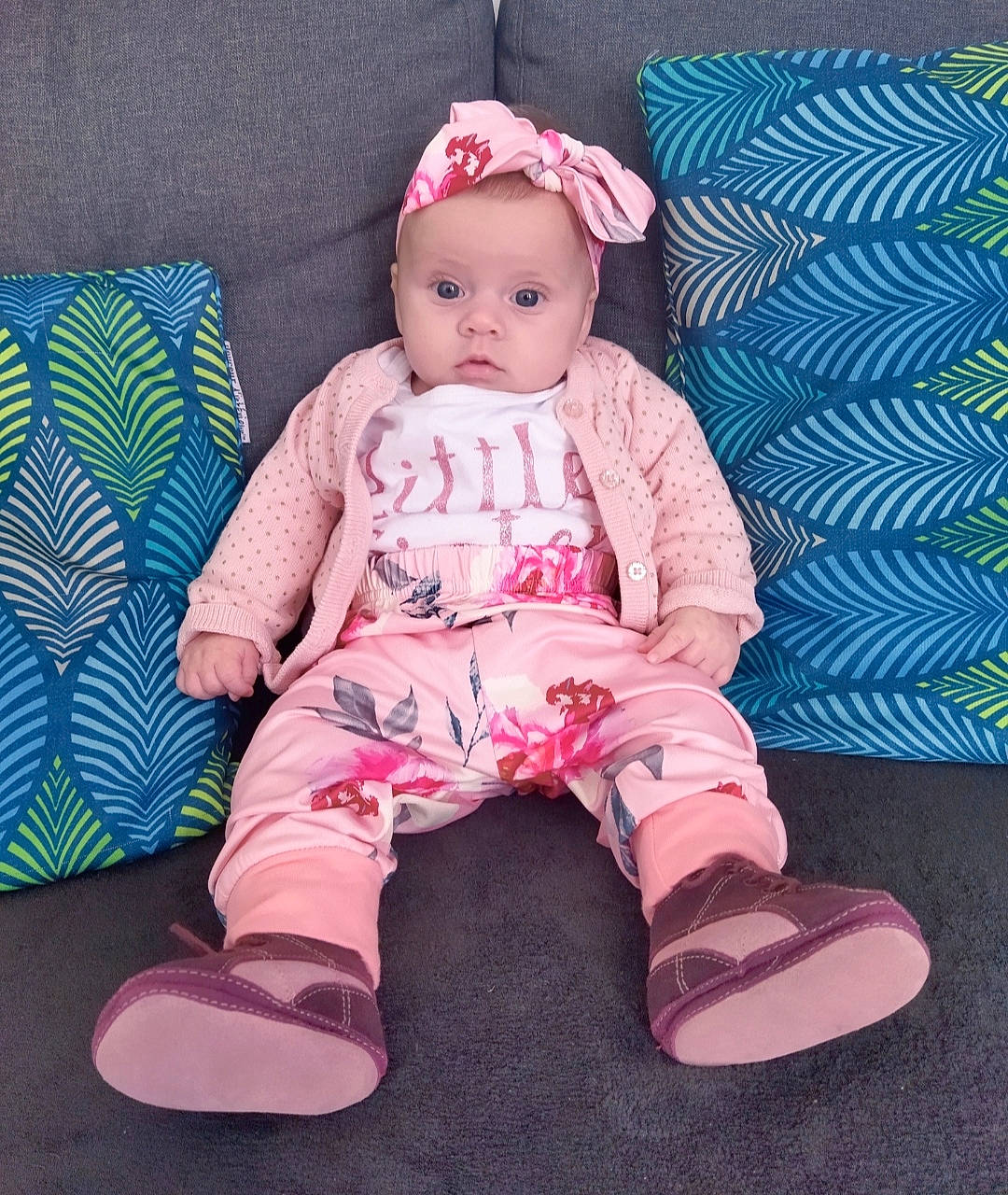 Joy a rejoint le concours — aidez-le/la à gagner de superbes lots ! arm, baby, baby_toddler_clothing, cap, cheek, child, comfort, eye, face, foot, headwear, human_body, knee, magenta, outerwear, pattern, person, pink, sitting, skin