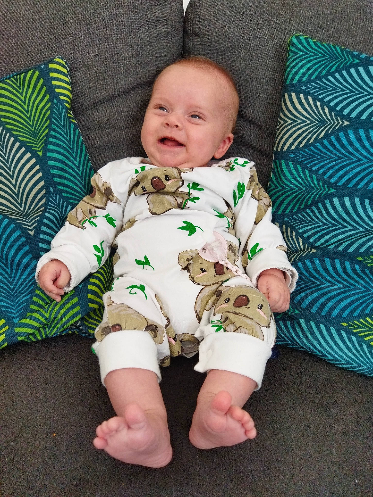 Joy participe au concours pour gagner de l'argent avec cette photo : baby, baby_toddler_clothing, barefoot, cheek, collar, comfort, eye, face, facial_expression, flooring, foot, head, human_body, linens, pattern, person, skin, sleeve, smile, t_shirt