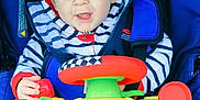 Stan participe au concours pour gagner de l'argent avec cette photo : baby, infant, child, stroller, toy_steering_wheel, hooded_jacket, striped_clothing, blue_eyes, smile, hand, seat_belt, colorful_toy, fabric, portrait, close_up, sitting, outdoor, clothing, happy, playful