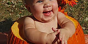 Elora is registered to the contest to win money with this photo: baby, pumpkin, flower_crown, smiling, outdoor, autumn, orange, cute, child, nature, sunlight, happy, seasonal, holiday, fall, grass, headband, skin, portrait, celebration