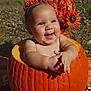 baby, pumpkin, flower_crown, smiling, outdoor, autumn, orange, cute, child, nature, sunlight, happy, seasonal, holiday, fall, grass, headband, skin, portrait, celebration