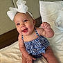 baby, child, smiling, happy, headband, bow, striped_clothing, blue, white, bed, pillow, indoor, cute, portrait, sitting, infant, skin, person, young, cheerful
