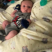 King joined the competition — help win amazing prizes! baby, infant, blanket, pacifier, mittens, clothing, onesie, person, face, cute, indoor, soft, patterned_blanket, resting, newborn, small, lying_down, cozy, expression, blue_eyes