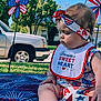 baby, child, outdoor, patriotic, red_white_blue, bib, headband, pinwheel, grass, blanket, toy, summer, sunny, vehicle, face, socks, flag, holiday, cute, portrait