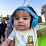 Elijah joined the competition — help win amazing prizes! adult_hand, baby, bib, casual, child, clothing, curious, cute, daylight, ear_protection, facial_expression, headphones, nature, outdoor, people, person, portrait, sky, tree, winnie_the_pooh
