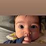 Elijah is registered to the contest to win money with this photo: baby, bedding, blanket, child, close_up, cozy, cute, expression, eyes, face, hand, head, indoors, infant, person, portrait, skin, sleepwear, soft, young