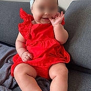 Catalina participe au concours pour gagner de l'argent avec cette photo : baby, child, red_dress, headband, couch, gray_couch, blanket, sitting, indoors, smiling, finger_in_mouth, cute, infant, plump_legs, soft_lighting, comfortable, happy, portrait, person, young_child