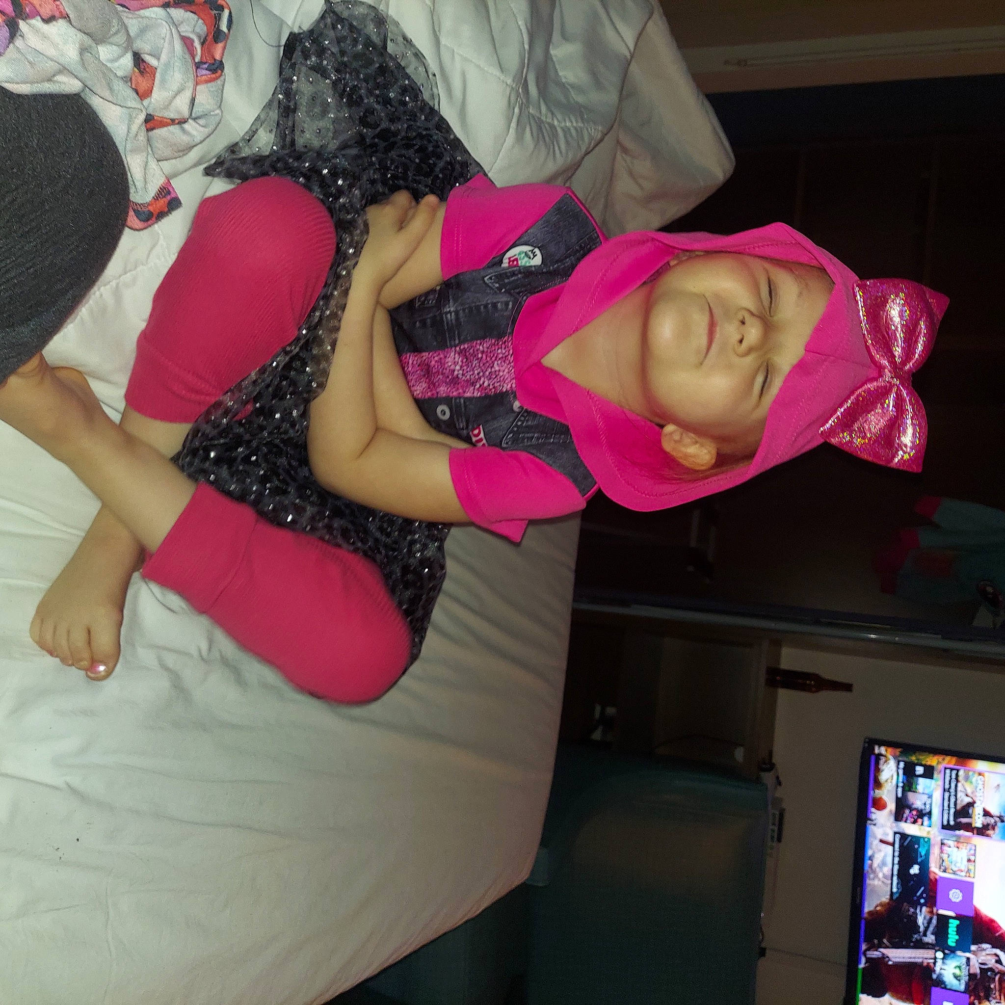 Alison is registered to the contest to win money with this photo: abdomen, chest, child, comfort, elbow, flesh, fun, hat, headwear, human_body, human_leg, knee, lap, magenta, pattern, person, pink, room, thigh, trunk