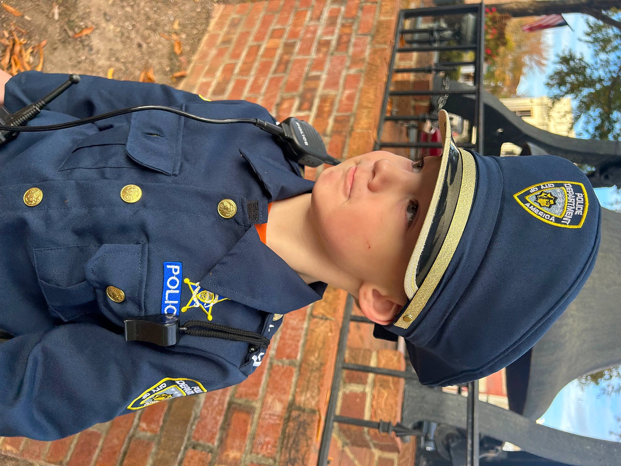 Carter is registered to the contest to win money with this photo: cap, electric_blue, gesture, headwear, law_enforcement, microphone, military, military_officer, military_person, military_uniform, official, person, personal_protective_equipment, police, police_officer, security, sleeve, tree, uniform