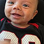 Nash is registered to the contest to win money with this photo: baby, smiling, face, child, closeup, happy, person, clothing, black_shirt, red_trim, number_23, skin, eyes, mouth, hand, infant, cute, portrait, young, joyful