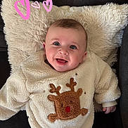Gianni a rejoint le concours — aidez-le/la à gagner de superbes lots ! baby, casual, child, clothing, cozy, cute, cute_expression, face, fluffy, happy, heart_doodle, indoor, infant, pillow, portrait, reindeer, relaxed, smiling, sweater, warm